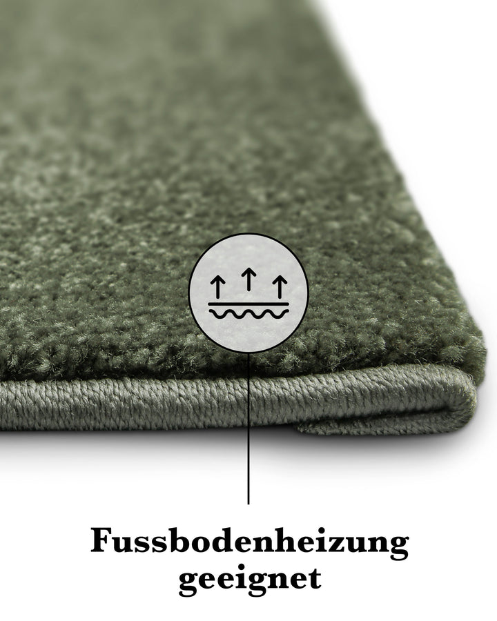 Kurzflor Teppich Freja Laub Grün Detailaufnahme der Kante mit Symbol für Fußbodenheizung geeignet