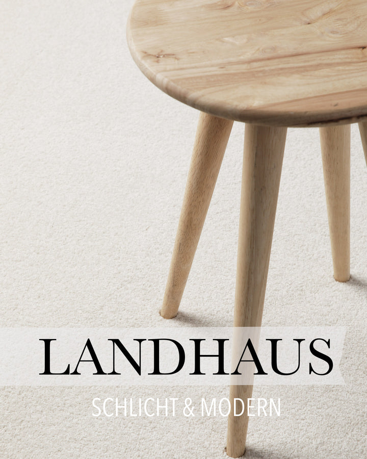 Kurzflor Teppich Freja Creme Weiß im Wohnraum mit Schriftzug Landhaus, zeigt warme Wohnatmosphäre