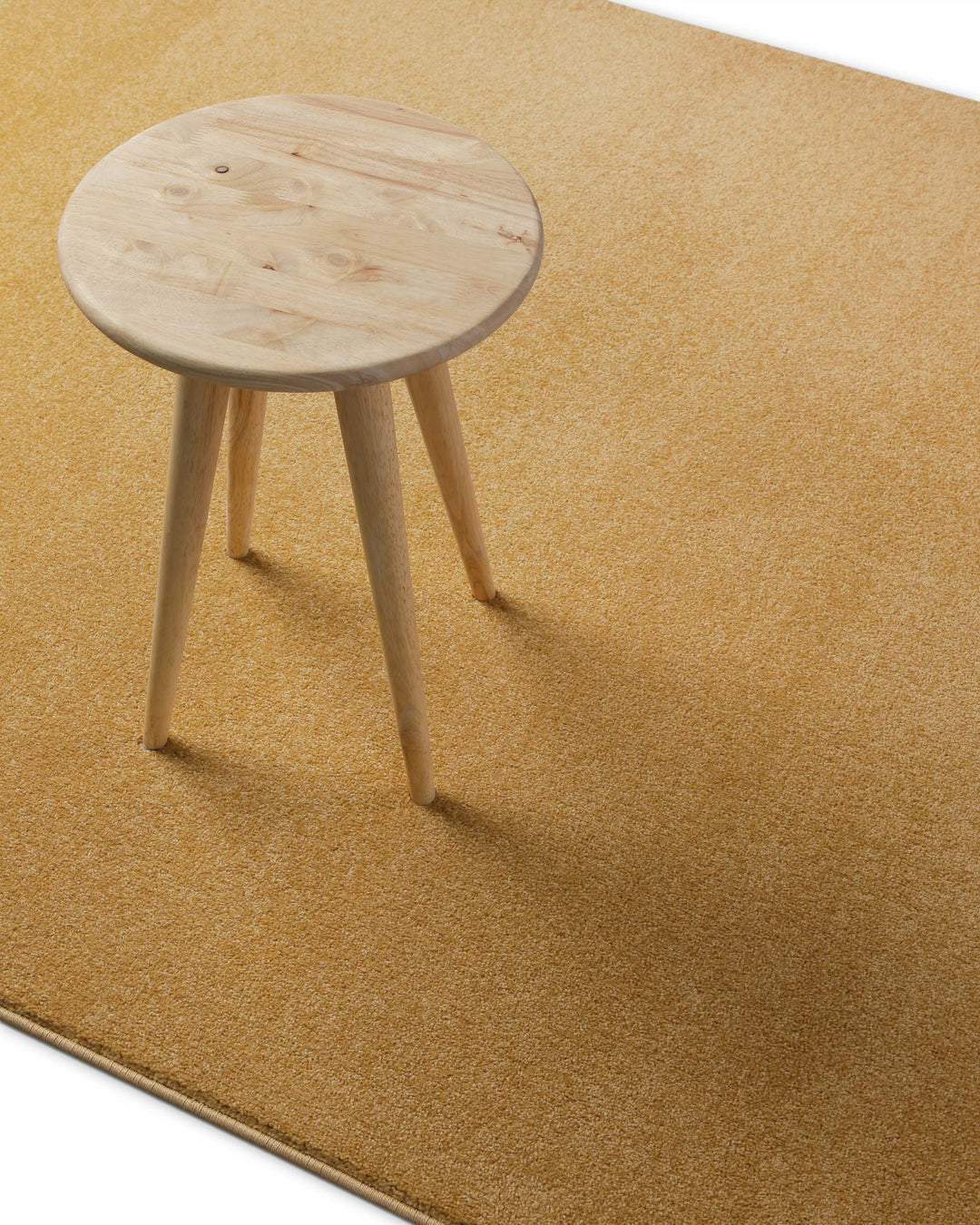 Im Raum platziert mit Hocker zeigt sich die warme, leicht goldene Farbwirkung besonders deutlich