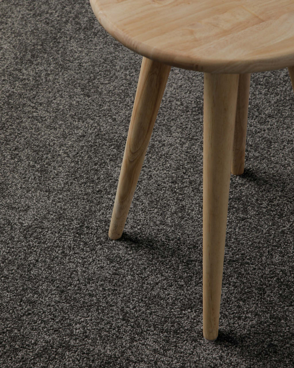 Im Raum platziert mit Hocker wirkt der dunkle Farbton ruhig und modern, mit leicht melierter Oberfläche