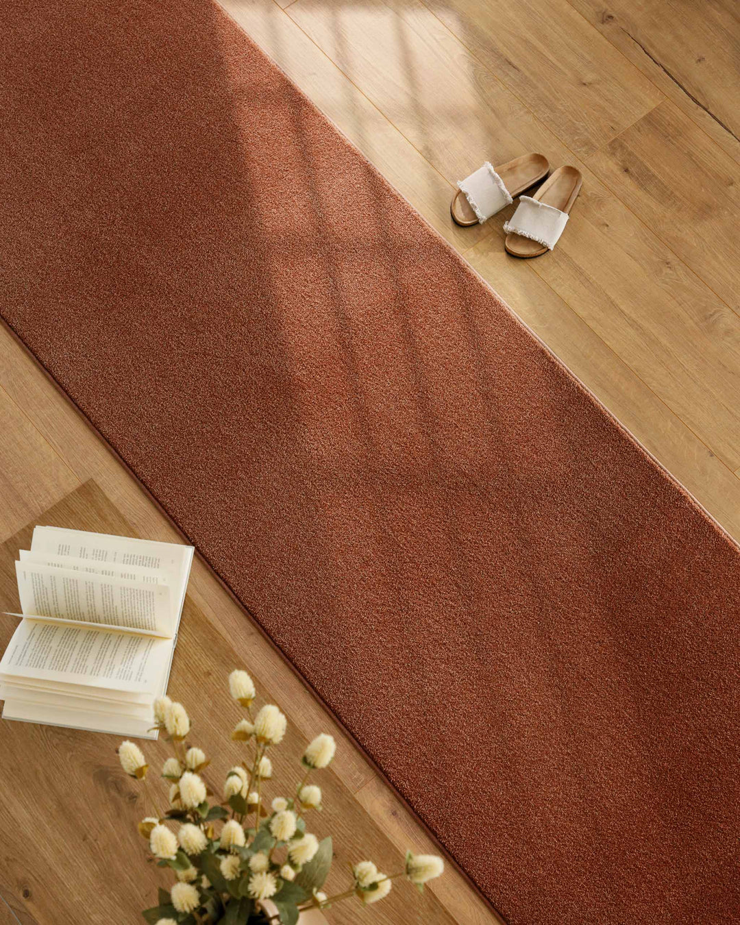 Kurzflor Teppich Läufer Vegas Rot im Wohnraum entlang Möbeln auf Holzboden, lange schmale Form sichtbar