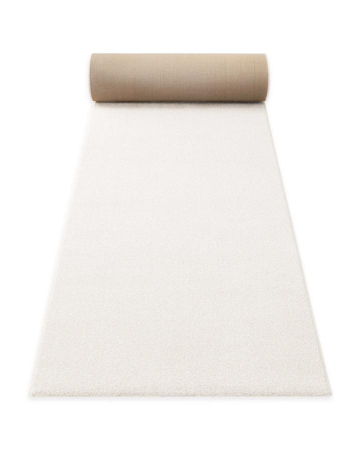 Kurzflor Teppich Läufer Vegas Creme aufgerollt, Seitenansicht zeigt Florhöhe und textile Rückseite