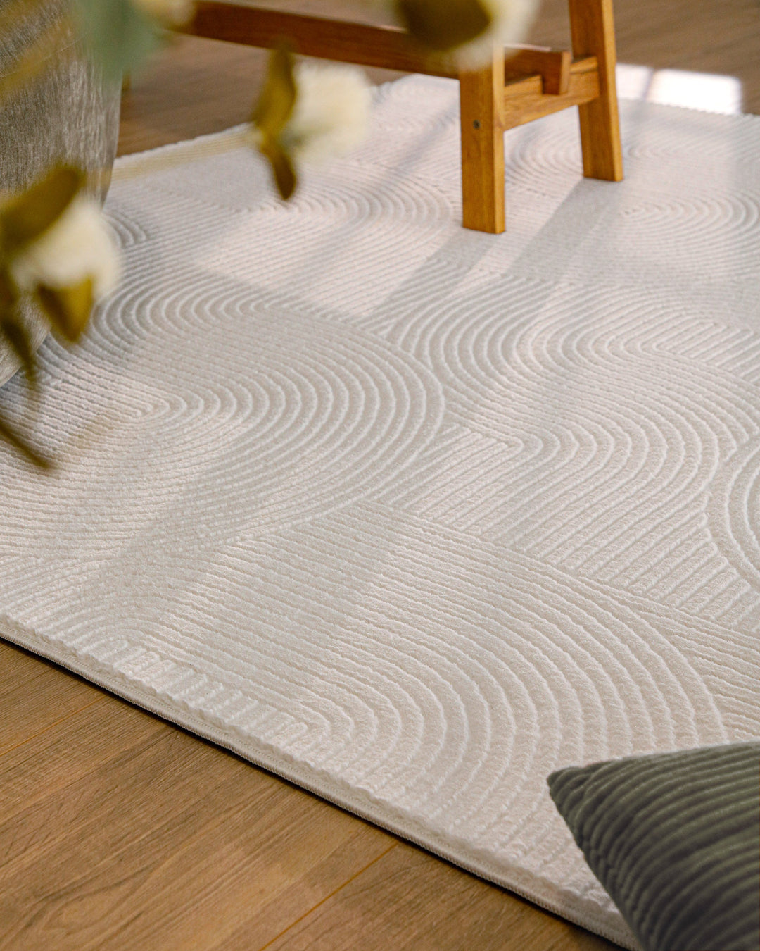 Nuuk Arc Teppich creme-weiß unter Holztisch im Wohnbereich