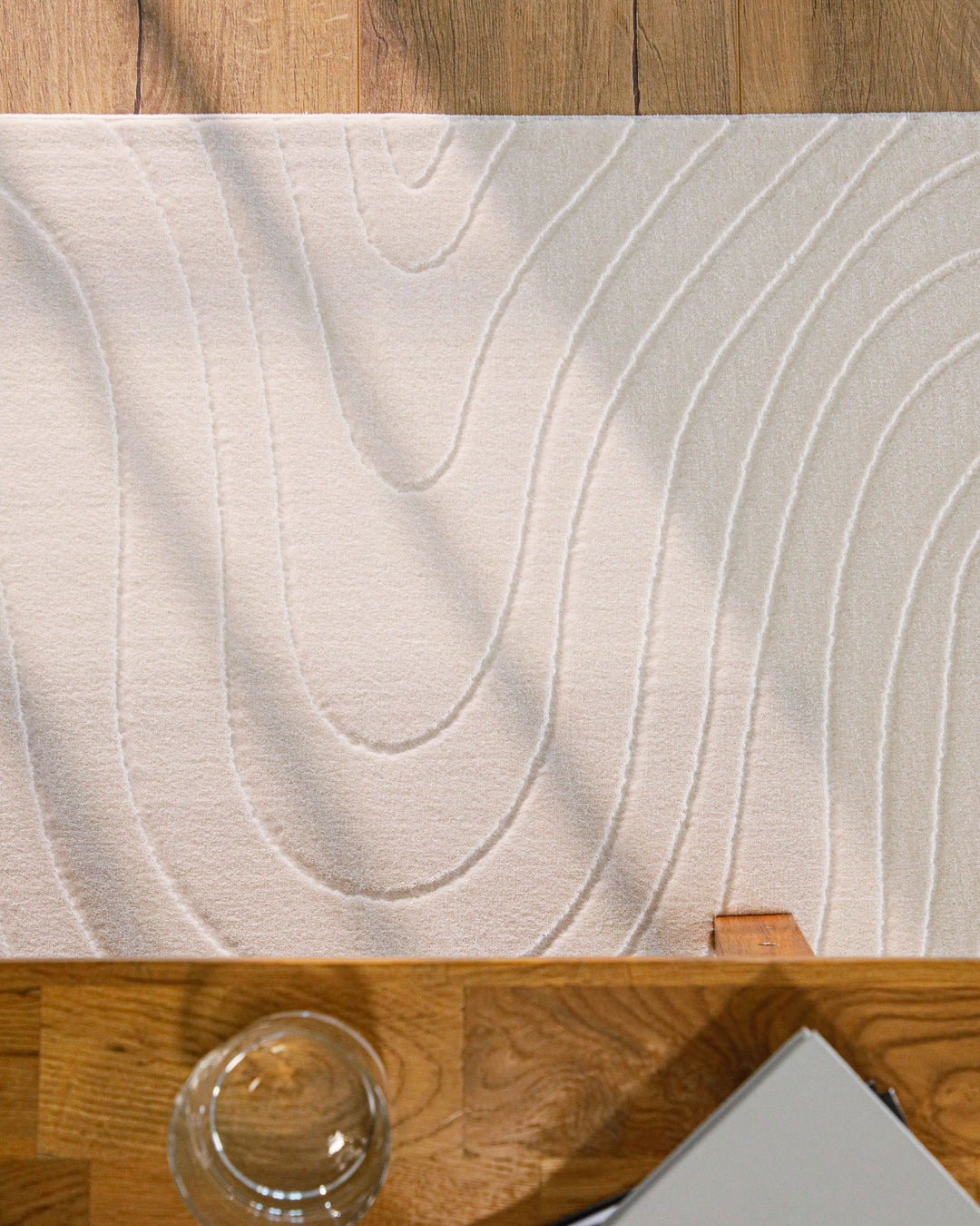 Kurzflor Teppich creme-weiß Wellenmuster Detail unter Tisch