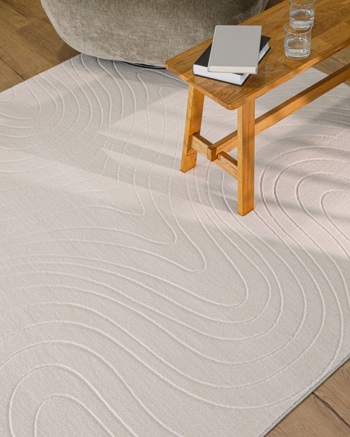 Nuuk Flow Teppich creme-weiß Wohnbereich mit Tisch und Hocker