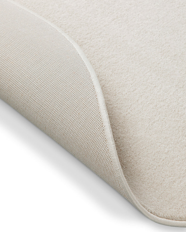 Kurzflor Teppich Freja Creme Weiß rund Detail der umgelegten Ecke, Rückseite sichtbar