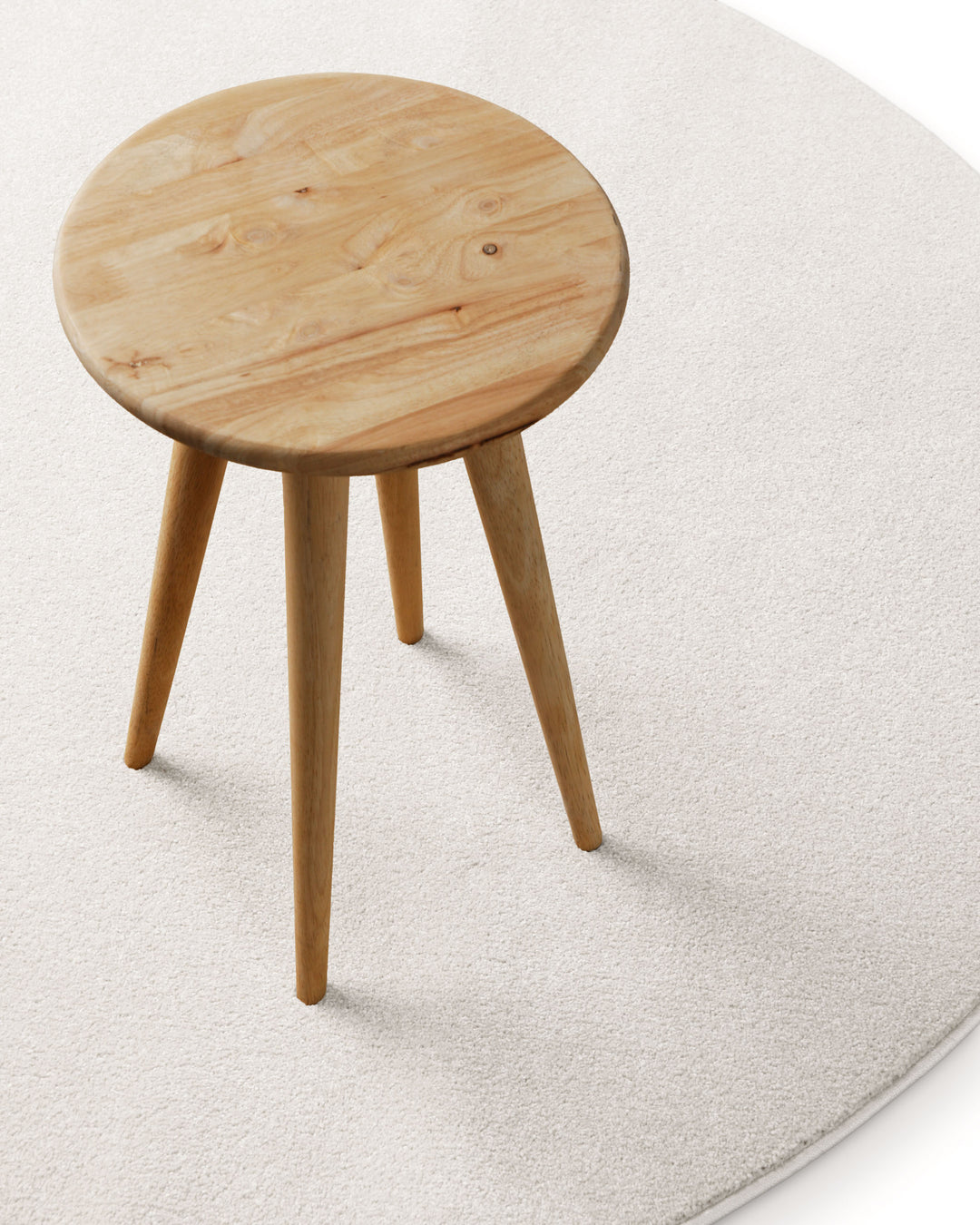 Kurzflor Teppich Freja Creme Weiß rund im Wohnraum mit Hocker, zeigt helle und ruhige Farbwirkung