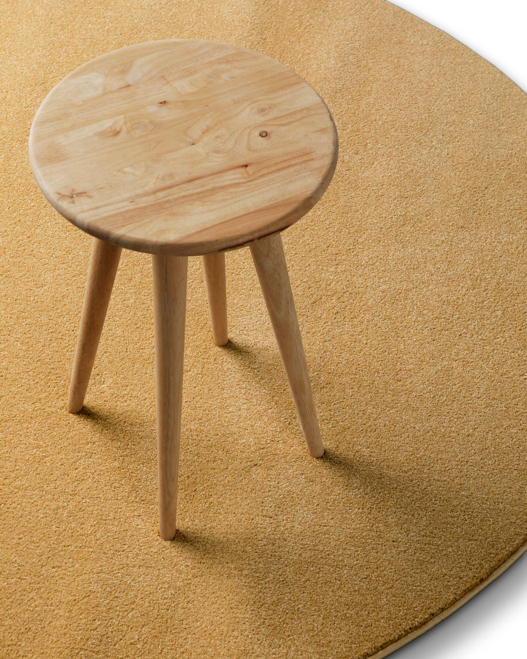 Im Raum platziert wirkt der Farbton warm und leicht golden, kombiniert mit einem schlichten Holz-Hocker