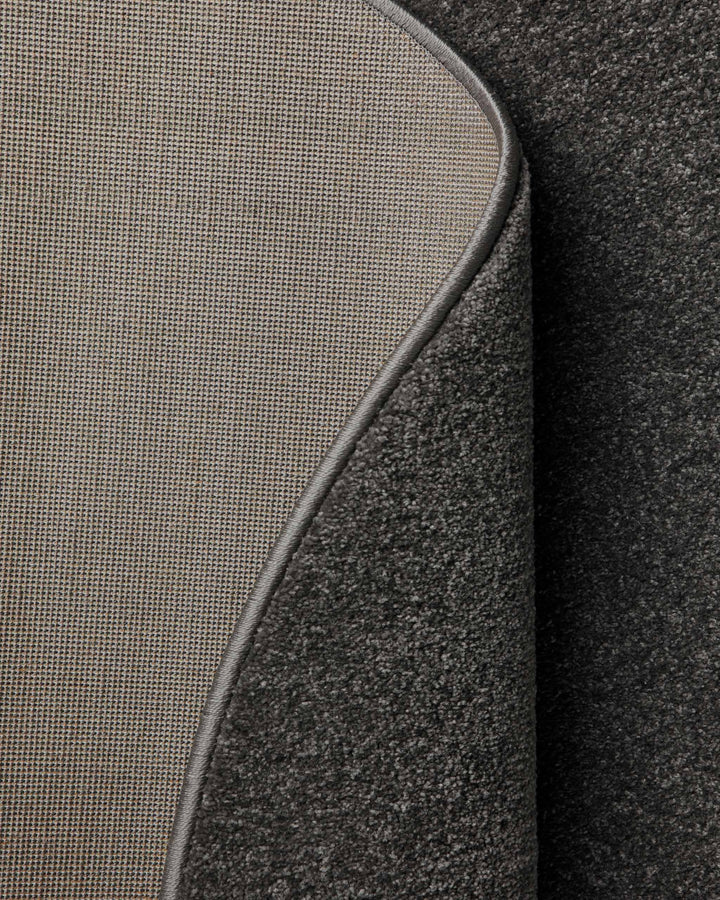 Kurzflor Teppich Montepulciano Anthrazit Grau rund, Rückseite sichtbar mit Jute-Träger und umgelegter Ecke