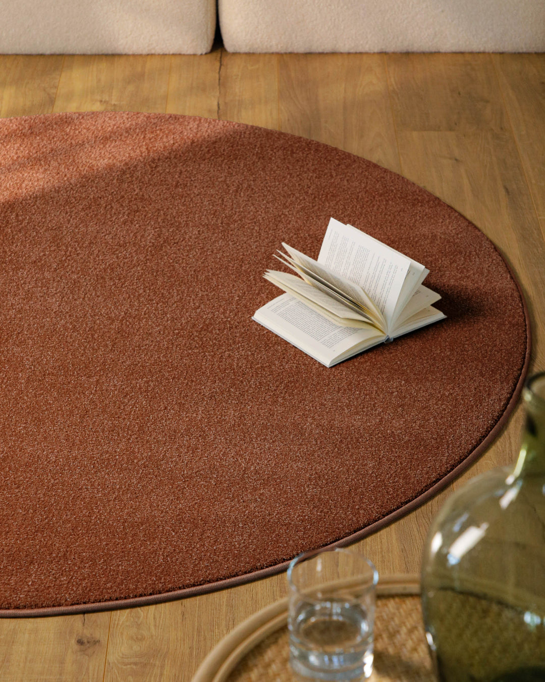 Kurzflor Teppich Vegas Rot rund im Wohnraum aus Draufsicht, Beistelltisch und Deko auf der Fläche