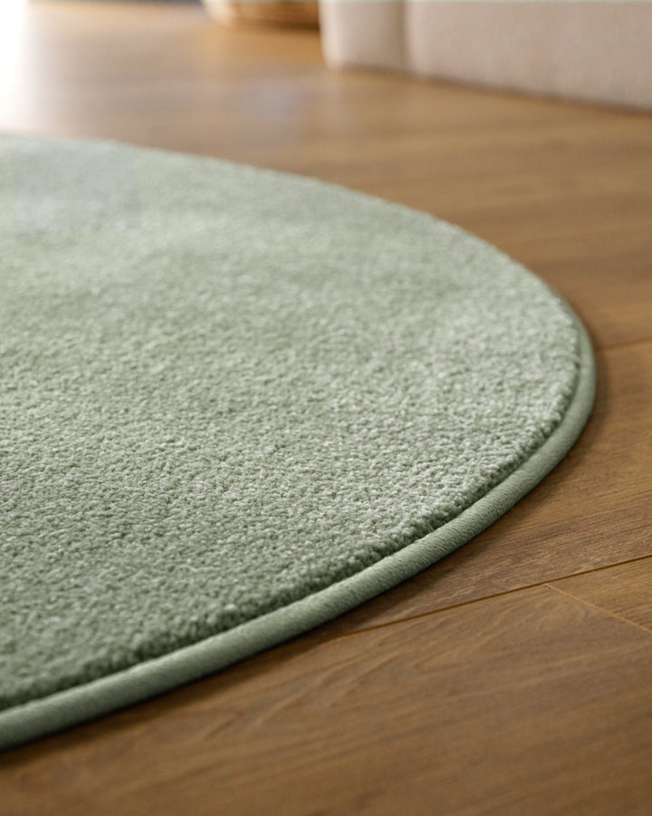 Kurzflor Teppich Vegas Hellgrün rund Detail der Teppichkante auf Holzboden, dichter Flor entlang der Rundung