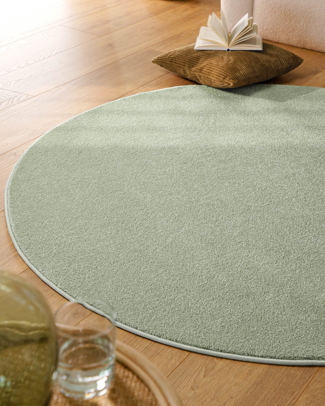 Kurzflor Teppich Vegas Hellgrün rund im Wohnzimmer aus Perspektive, Licht fällt über die Oberfläche
