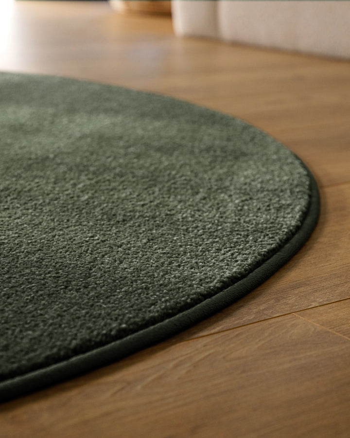 Kurzflor Teppich Vegas Grün rund Detail der Kante auf Holzboden, dichter Flor entlang der runden Außenkante