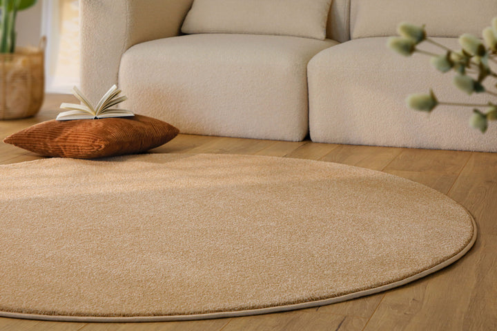 Kurzflor Teppich Vegas Beige rund im Wohnraum aus schräger Perspektive mit Lichteinfall