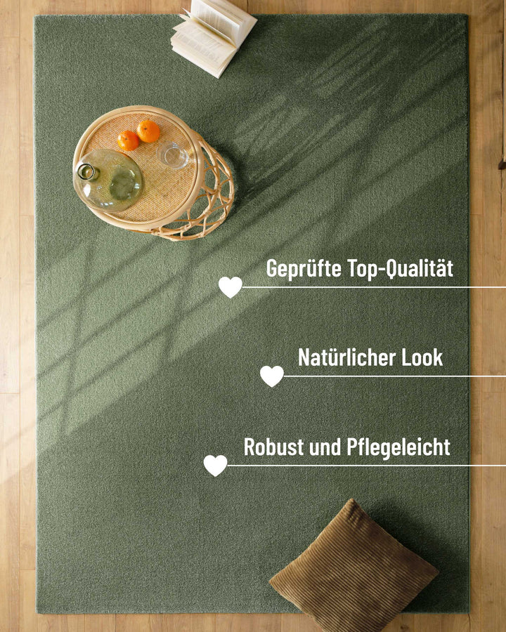 Kurzflor Teppich Vegas Grün im Raum mit Einblendung zu Eigenschaften, Oberfläche mit Licht und Möbeln sichtbar