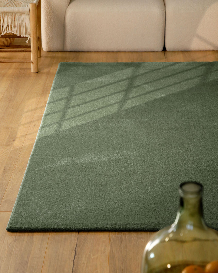 Kurzflor Teppich Vegas Grün im Wohnzimmer aus schräger Perspektive, Licht fällt über die Oberfläche