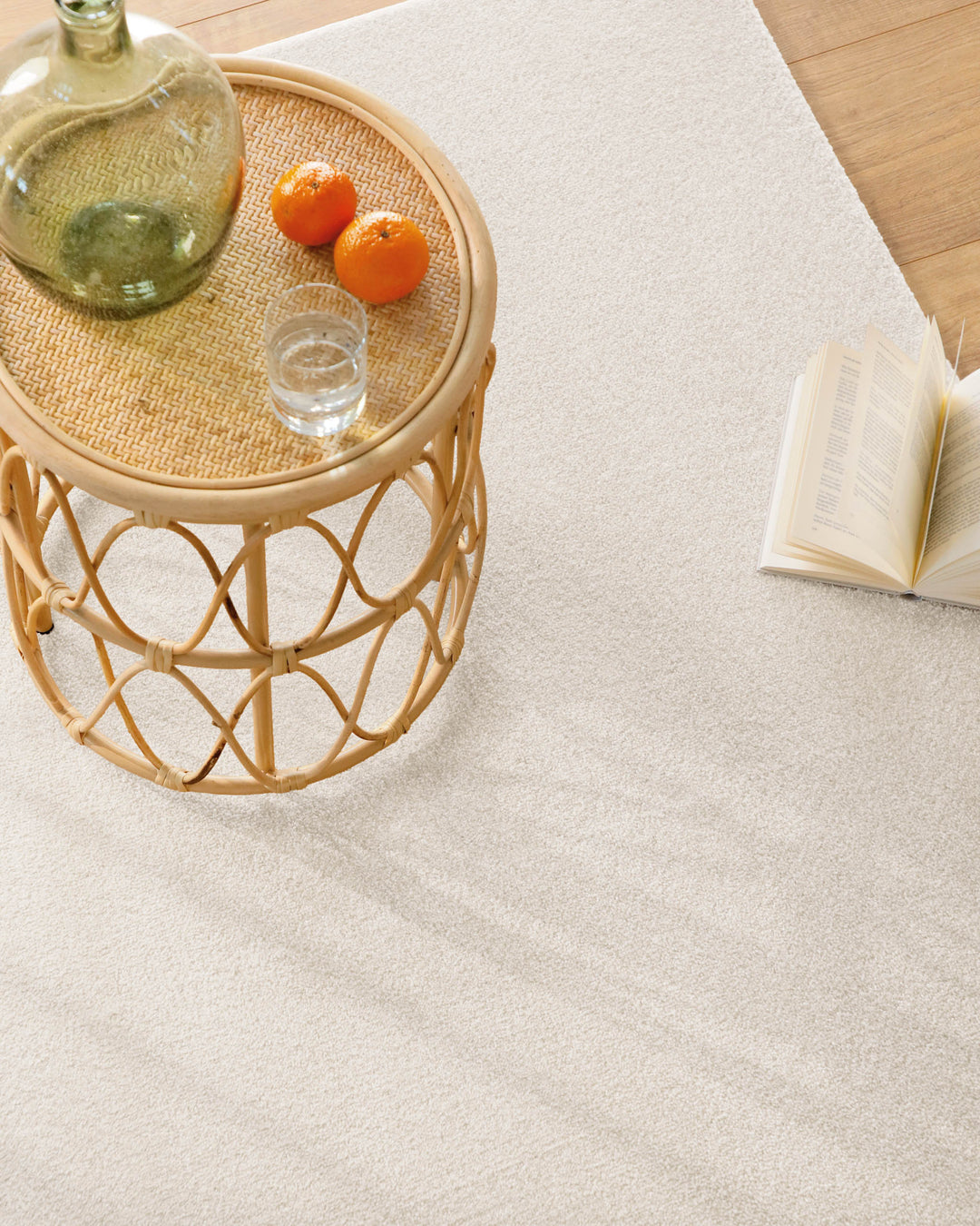 Kurzflor Teppich Vegas Creme Nahaufnahme mit Beistelltisch und Buch auf der Oberfläche, feine Struktur erkennbar