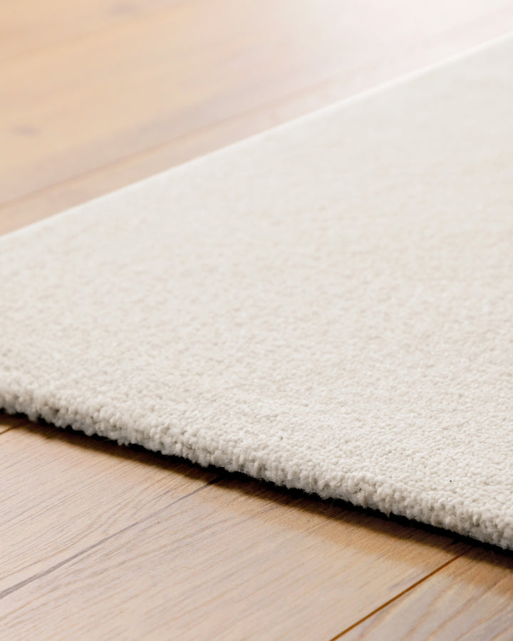 Kurzflor Teppich Vegas Creme Detail der Teppichkante auf Holzboden, flacher Abschluss und gleichmäßige Struktur