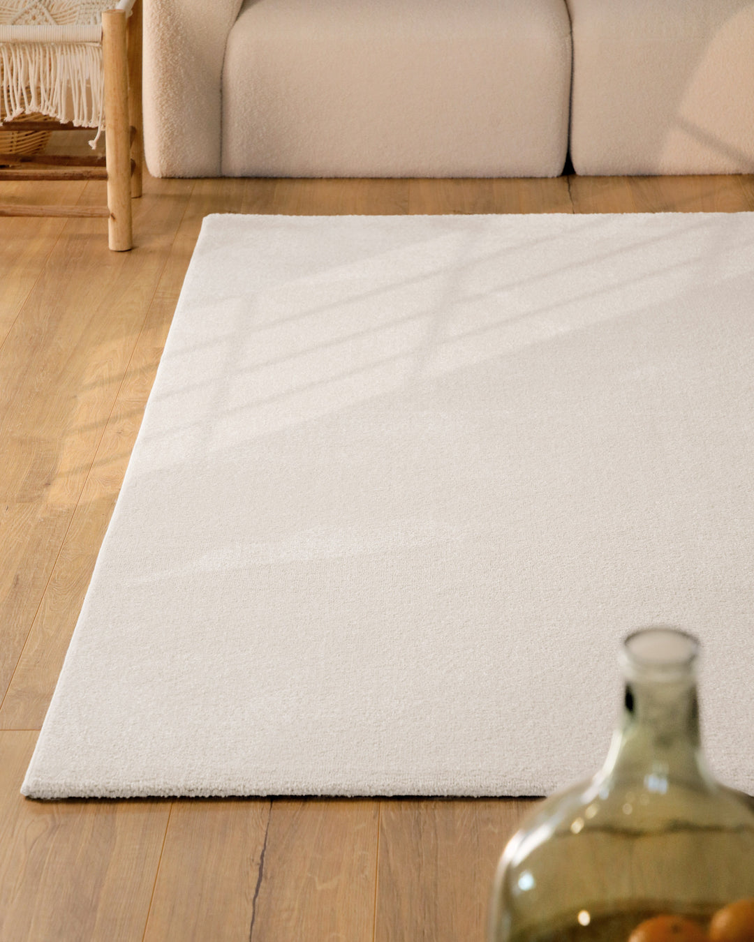 Kurzflor Teppich Vegas Creme im Wohnzimmer aus schräger Perspektive, Licht fällt über die Oberfläche