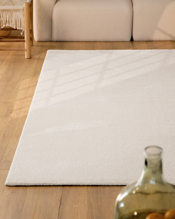 Kurzflor Teppich Vegas Creme im Wohnzimmer aus schräger Perspektive, Licht fällt über die Oberfläche