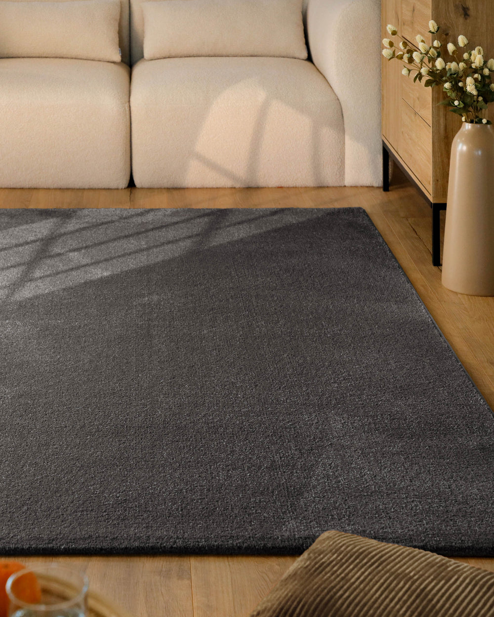 Kurzflor Teppich Vegas Anthrazit im Wohnzimmer vor Sofa auf Holzboden, moderner Kontrast