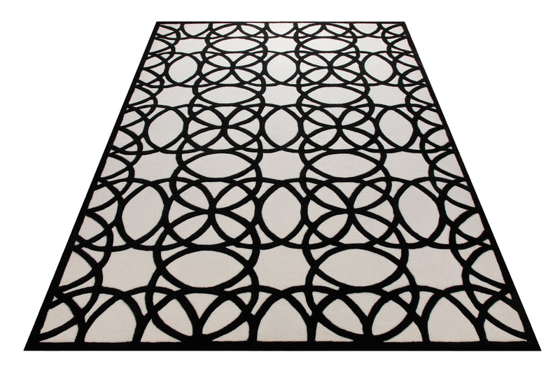 Schwarz auf Weiß - Handtuft mit Kreisornament 160 x 230 cm – Teppich im Raum platziert
