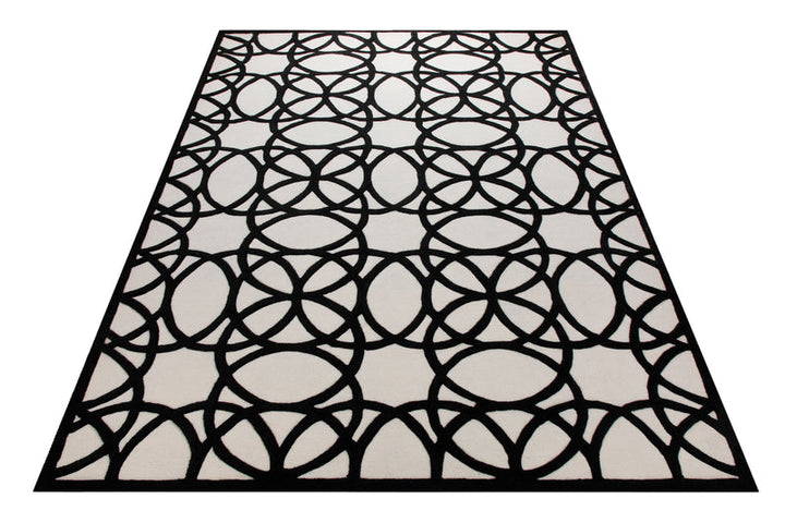 Schwarz auf Weiß - Handtuft mit Kreisornament 160 x 230 cm – Teppich im Raum platziert