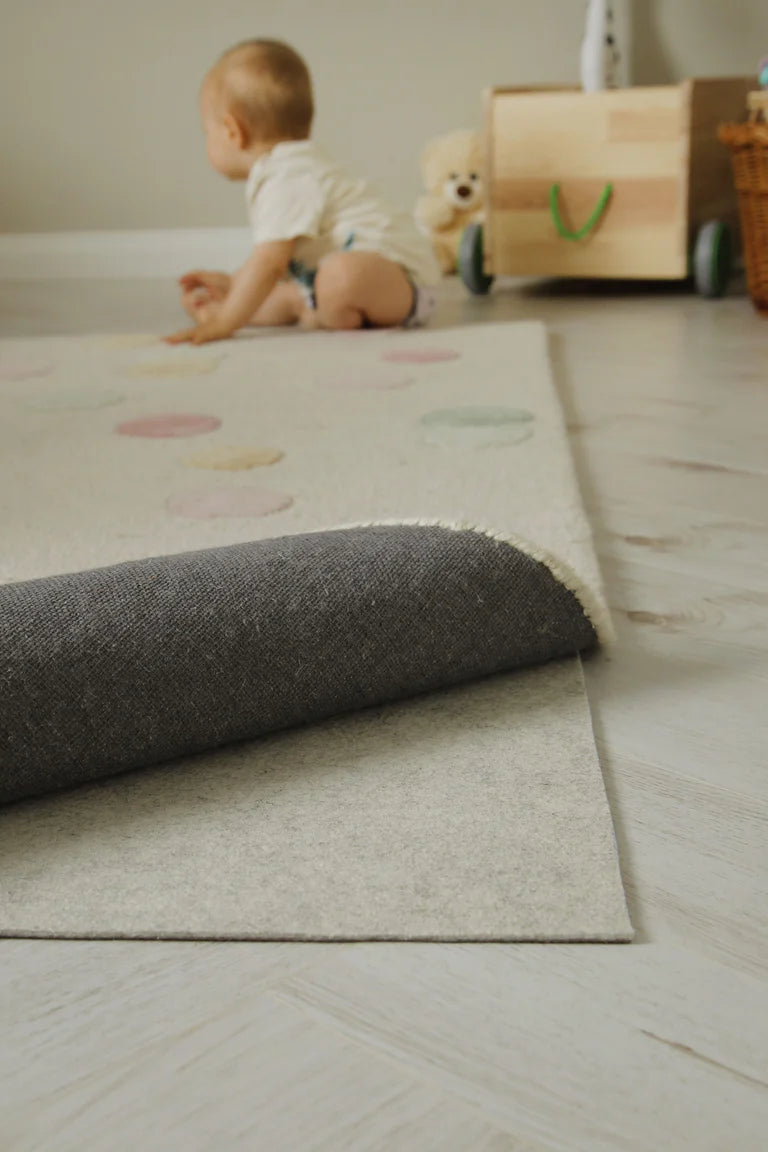 RugPad liegt unter einem Teppich mit hochgeklappter Ecke im Kinderzimmer