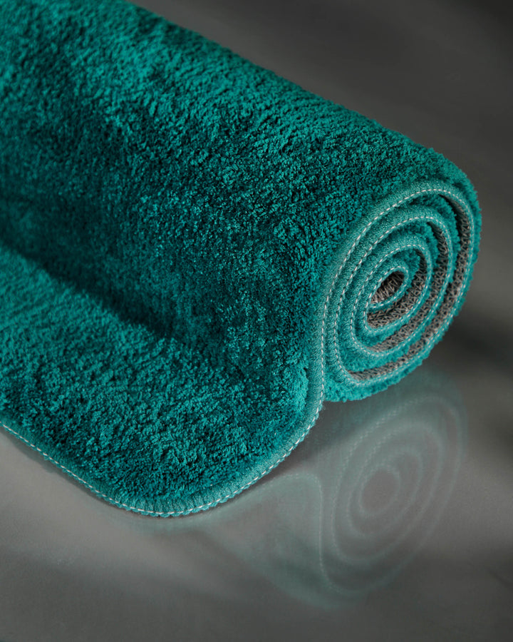 Badematte Badteppich Joris Petrol flauschig aufgerollt